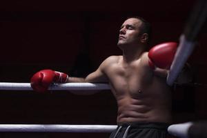 kick boxer resting on the ropes in the corner photo