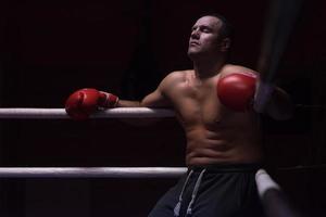 kick boxer resting on the ropes in the corner photo