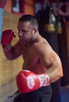 kick boxer entrenando en un saco de boxeo foto