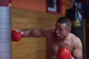 kick boxer training on a punching bag photo