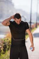 man pouring water from bottle on his head photo