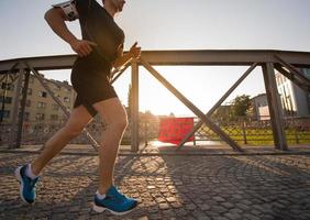 hombre corriendo por el puente en la mañana soleada foto