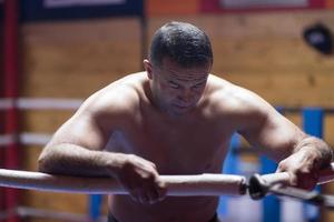 kick boxer resting on the ropes in the corner photo