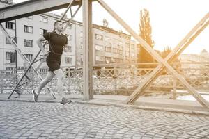 hombre corriendo por el puente en la mañana soleada foto