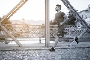 hombre corriendo por el puente en la mañana soleada foto