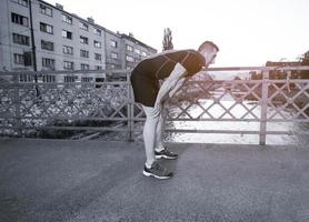 man jogging across the bridge at sunny morning photo