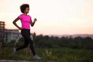 una joven afroamericana trotando al aire libre foto