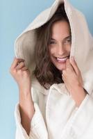 woman in a white coat with hood isolated on blue background photo