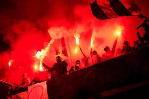 football hooligans with mask holding torches in fire photo