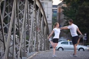 couple warming up and stretching before jogging photo