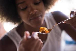 a young African American woman eating pasta photo