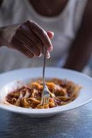 a young African American woman eating pasta photo