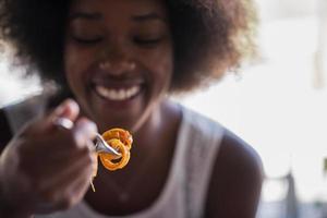 a young African American woman eating pasta photo