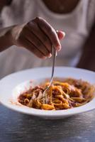 a young African American woman eating pasta photo