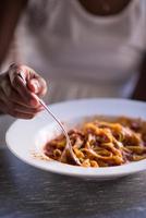 a young African American woman eating pasta photo