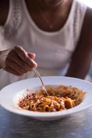 a young African American woman eating pasta photo