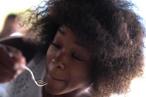 a young African American woman eating pasta photo