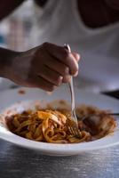 a young African American woman eating pasta photo