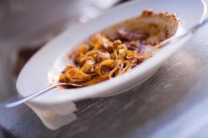 una joven afroamericana comiendo pasta foto