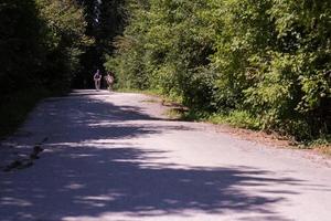 joven pareja multiétnica dando un paseo en bicicleta en la naturaleza foto