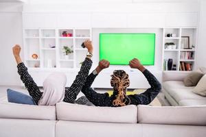 pareja africana sentada en el sofá viendo la televisión juntos foto