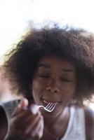 a young African American woman eating pasta photo