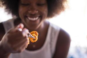 a young African American woman eating pasta photo