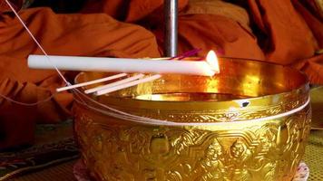 The candle was placed on the holy water bowl and was burning. which is a religious ceremony of Thailand. video