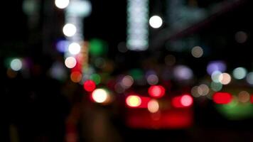 verschwommenes bokeh von autos im verkehr auf der straße bei nacht. abstraktes helles unscharfes farbiges bokeh. video