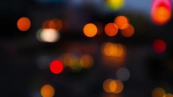 verschwommenes bokeh von autos im verkehr auf der straße bei nacht. abstraktes helles unscharfes farbiges bokeh. video