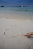 corazones dibujados en la arena de una playa foto