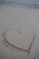 hearts drawn on the sand of a beach photo