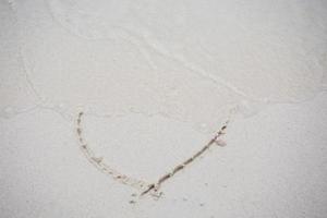 corazones dibujados en la arena de una playa foto