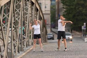 couple warming up and stretching before jogging photo