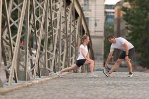 pareja calentándose y estirándose antes de trotar foto