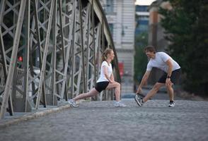 couple warming up and stretching before jogging photo