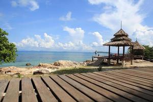 Wooden jetty on tropical beach on island photo