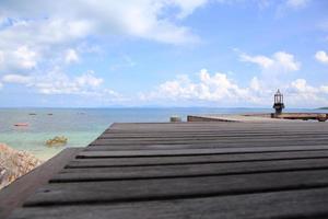 Wooden jetty on tropical beach on island photo