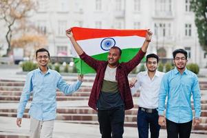 grupo de cuatro hombres indios del sur de asia con bandera india. foto