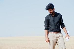 South asian agronomist farmer inspecting wheat field farm. Agriculture production concept. photo