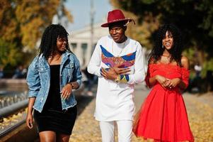 grupo de tres elegantes amigos de moda afro francia posaron en el día de otoño. modelo de hombre africano negro con dos mujeres de piel oscura. foto