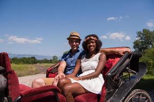 multiethnic couple sitting in a horse carriage photo