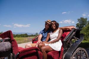 multiethnic couple sitting in a horse carriage photo