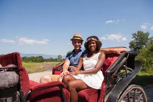multiethnic couple sitting in a horse carriage photo
