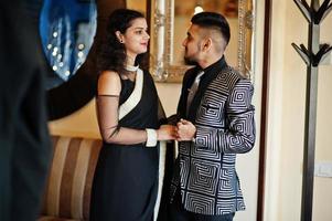 Lovely indian couple in love, wear at saree and elegant suit, posed on restaurant. photo