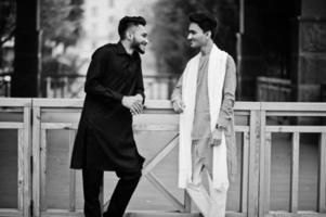 Two indian stylish mans friends in traditional clothes posed outdoor and talk each other. photo