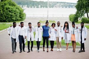 grupo de estudiantes de medicina africanos posaron al aire libre con batas blancas de laboratorio. foto