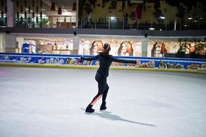 mujer patinadora artística en la pista de patinaje sobre hielo. foto