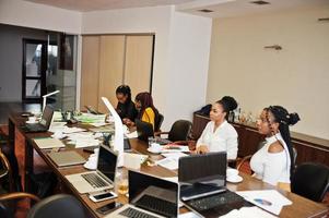 African american women colleagues, crew of divercity female partners in office sit at the table. photo