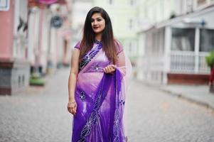 Indian hindu girl at traditional violet saree posed at street. photo